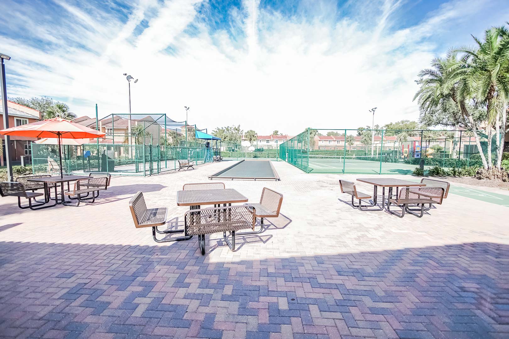 An airy view of the tennis courts and seating area at VRI's Fantasy World Resort in Florida.